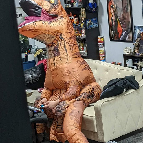 Tomb Raider Community streamer UnchartedRaider wearing a puffy T. rex costume while streaming during Extra Life marathon weekend.